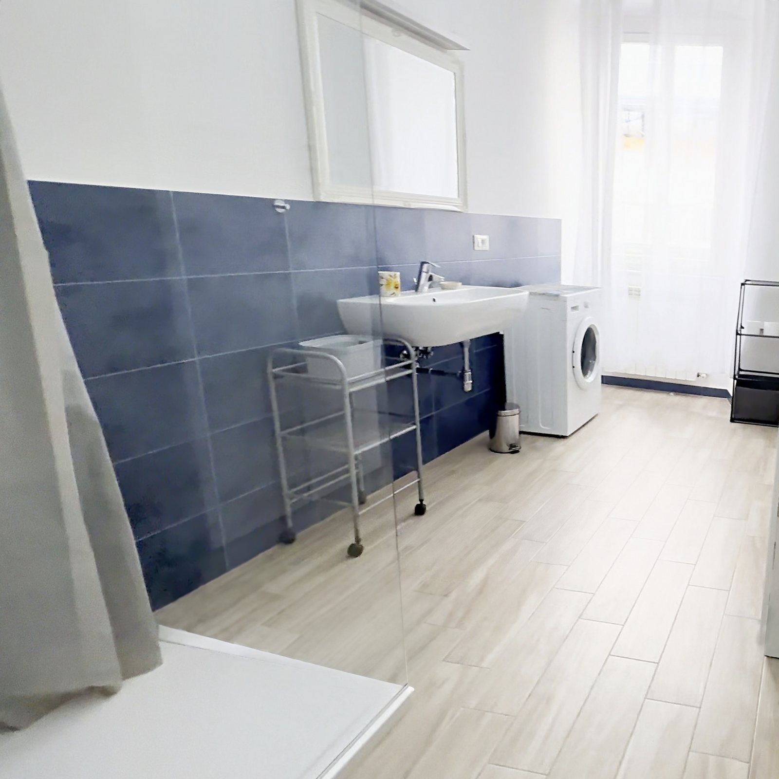 Bad mit Dusche mit Glaswand, langem Waschbecken und Waschmaschine, Via Machiavelli, Triest