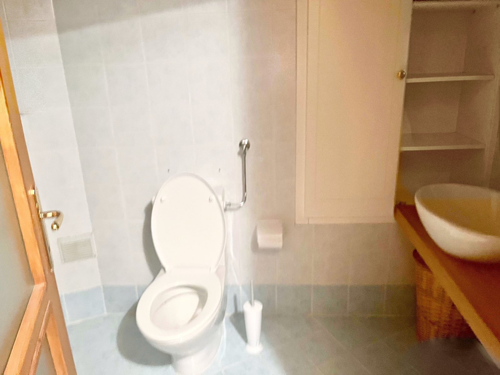 Bagno con lavabo d'appoggio su piano in legno, mobile alto bianco e mensole, via dei Capitelli, Trieste