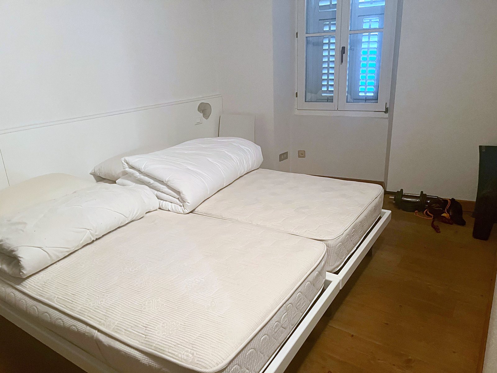 Stanza da letto con due letti singoli accostati e finestra con persiane, via dei Capitelli, Trieste