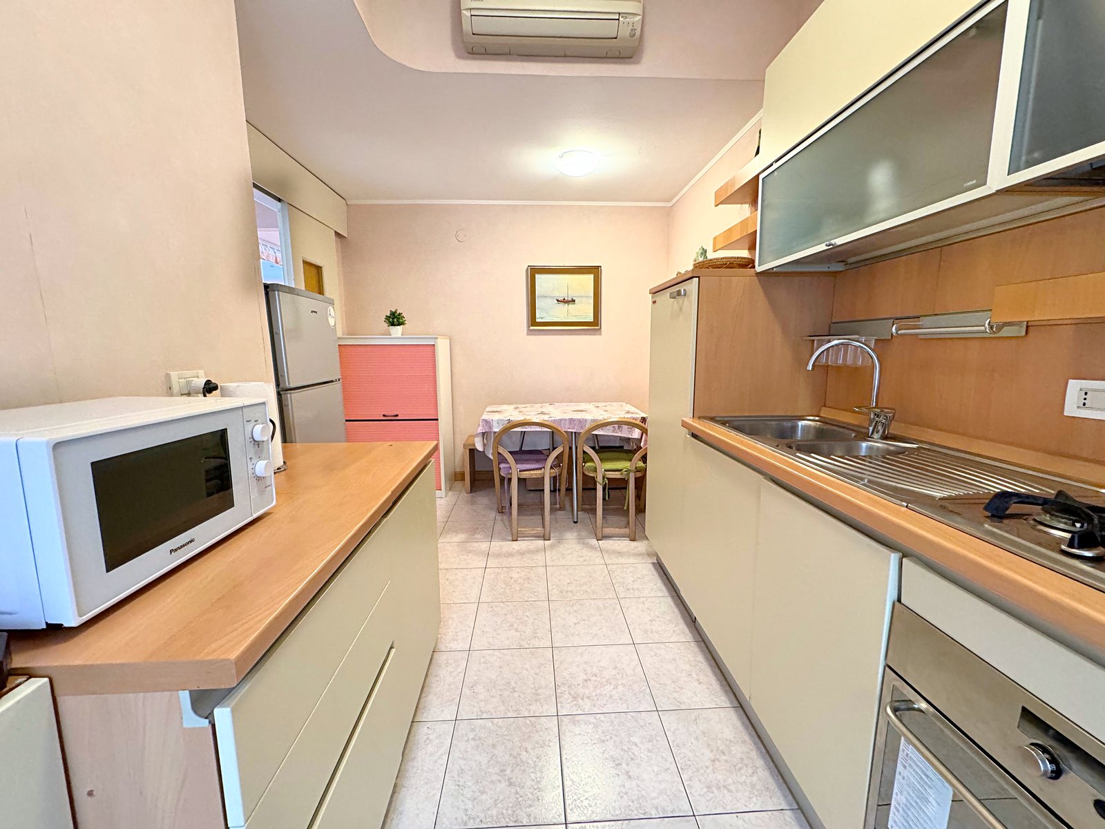 Galley kitchen with sink, oven and dining table at the end, flat in Via San Francesco d'Assisi, Trieste