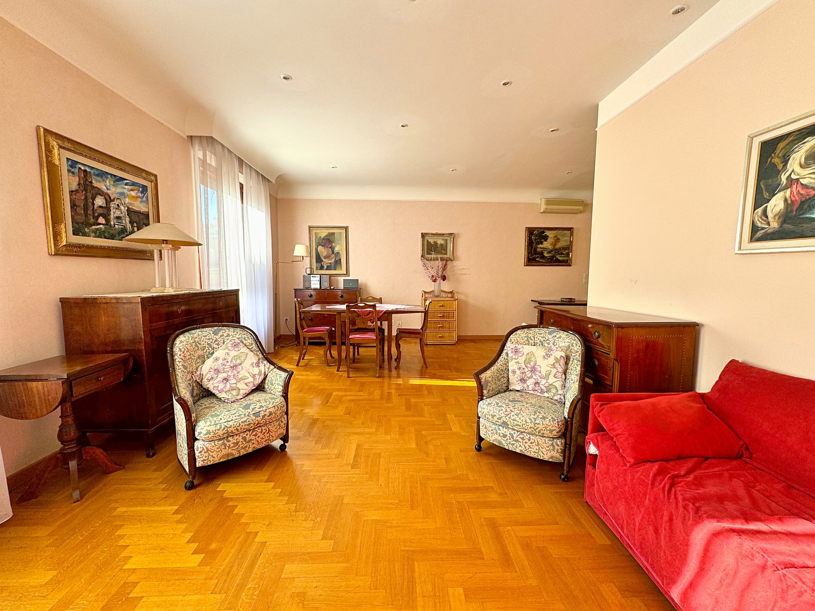 Large living room with floral armchairs, antique chests of drawers and dining area, Via San Francesco d'Assisi, Trieste