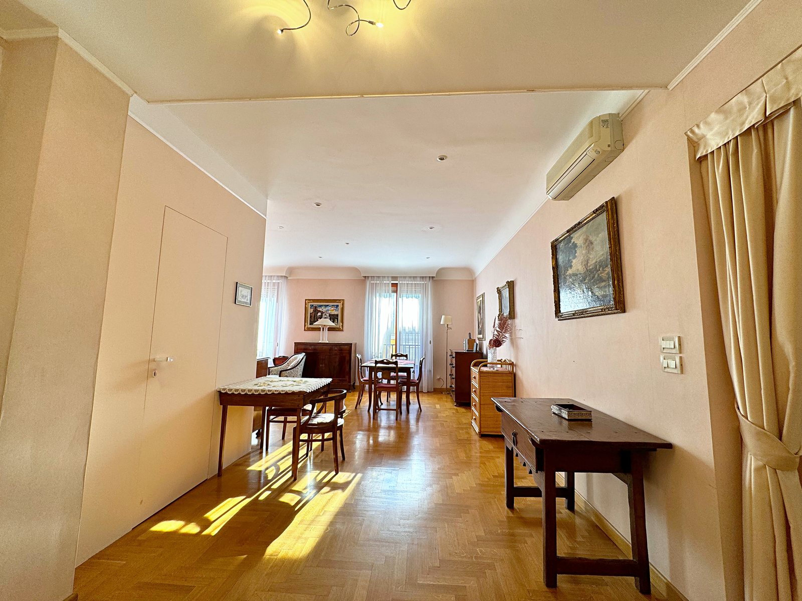 Long view through the living room with herringbone parquet and windows at the end, Via San Francesco d'Assisi, Trieste