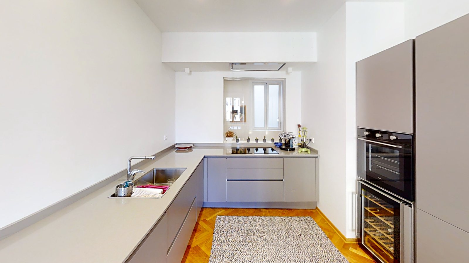 Küche mit grauen Schränken, Induktionskochfeld, Einbaubackofen und Weinkühlschrank, Via dei Fabbri, Triest