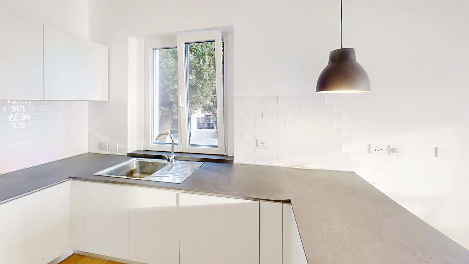 Kitchen corner with sink under the window and long grey stone worktop, Salita di Cedassamare, Trieste
