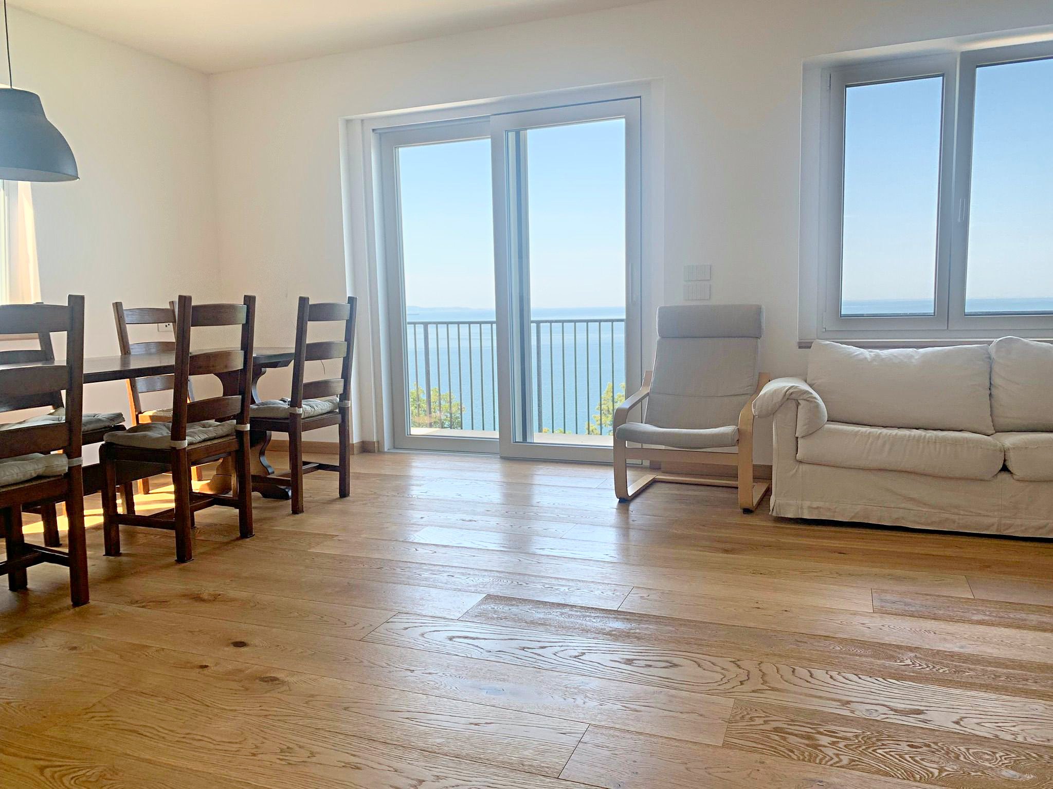 Living room with dining area and French window to the balcony with sea view, flat in Salita di Cedassamare, Trieste