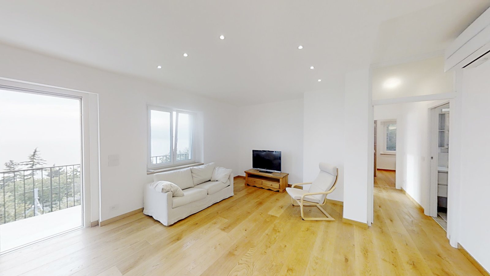 Bright living room with white sofa, TV and French window to the balcony, Salita di Cedassamare, Trieste