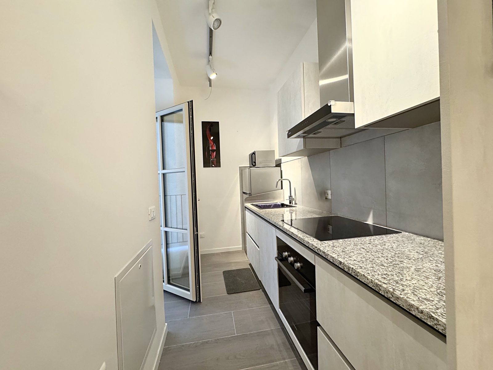 Galley kitchen with granite worktop, induction hob and French door to the small terrace, Via del Lavatoio, Trieste