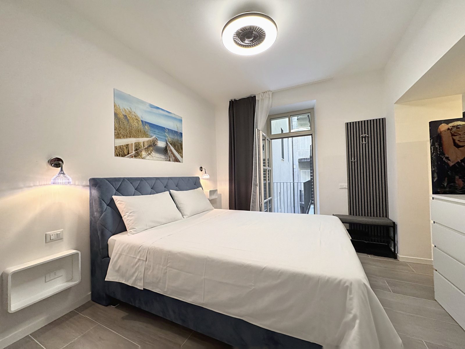 Double bedroom with quilted blue headboard, vertical radiator and door to the terrace, Via del Lavatoio, Trieste