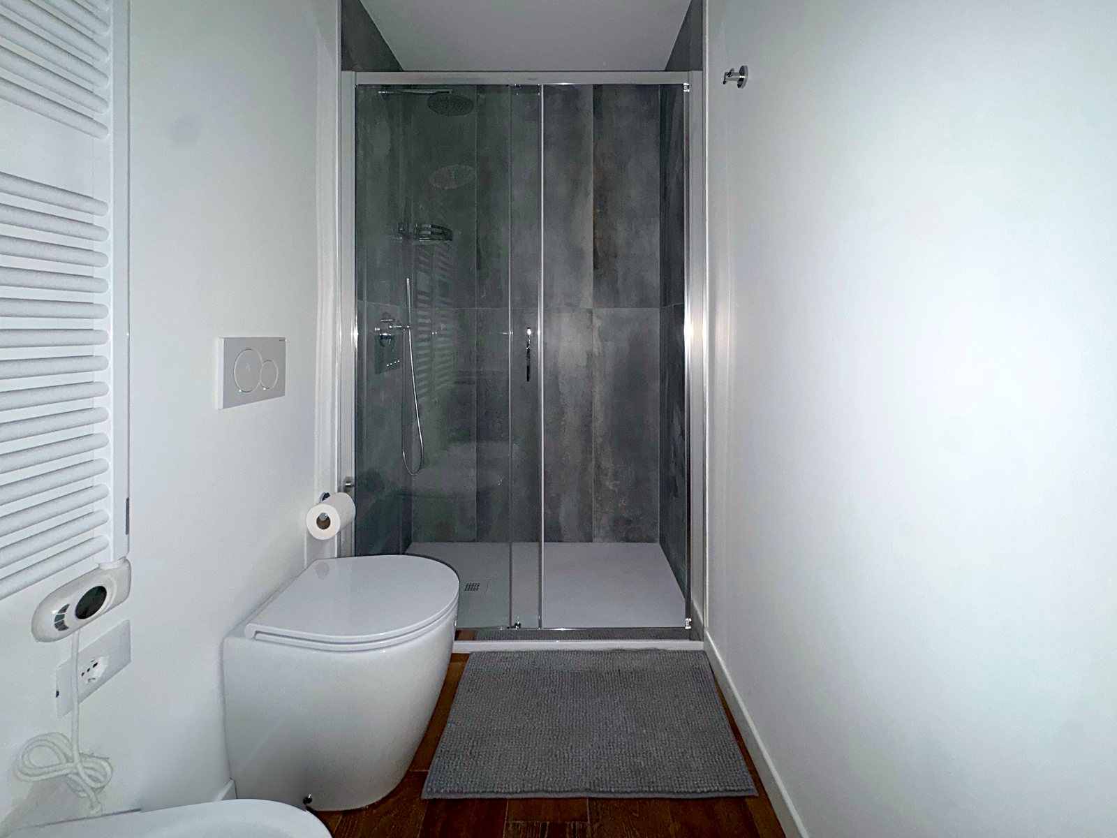 Doccia grande con box in cristallo e piastrelle grigie nel bagno, via Marconi, Trieste
