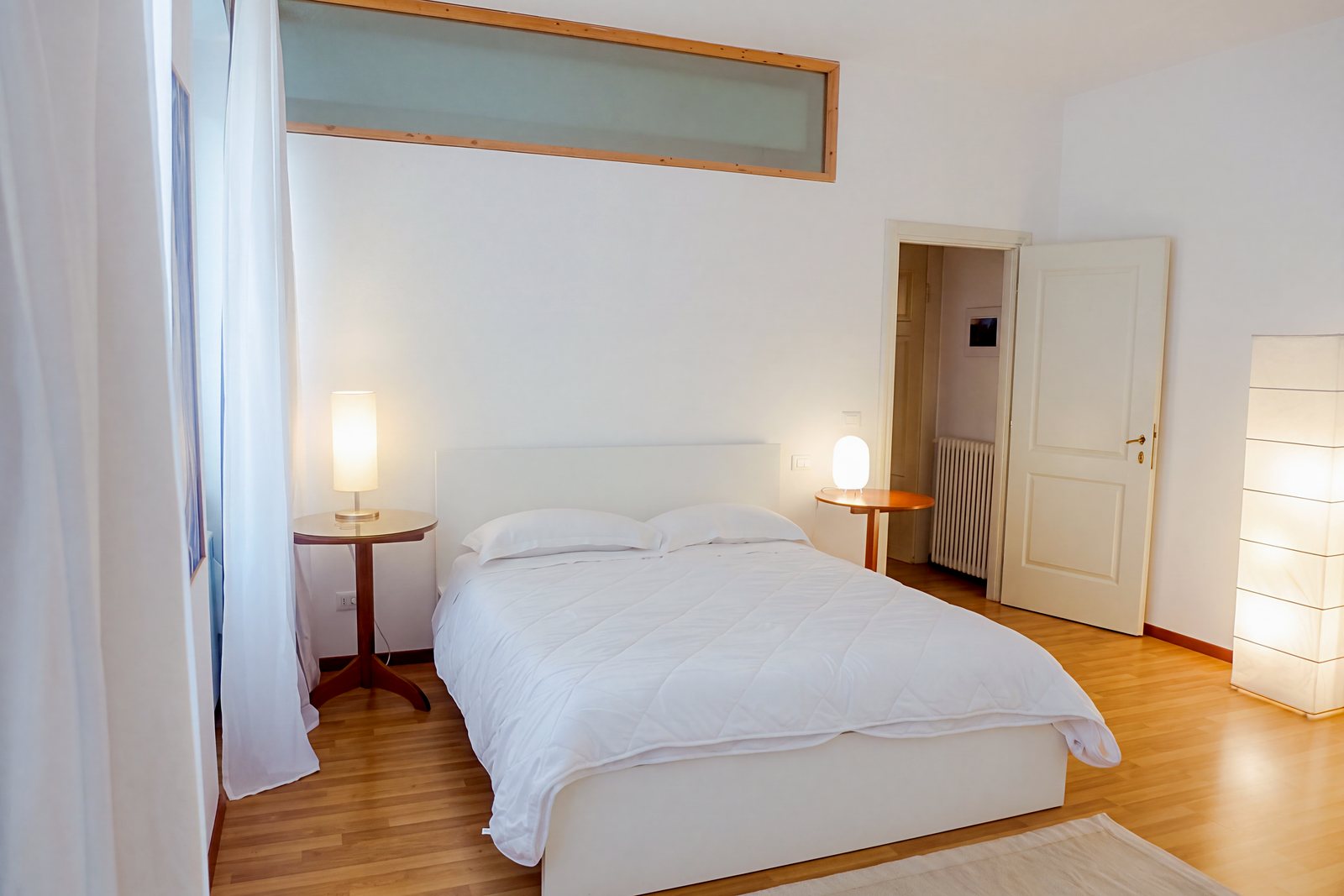 Schlafzimmer mit Milchglas-Oberlicht, runden Nachttischen und Papierstehlampe, Viale della Terza Armata, Triest