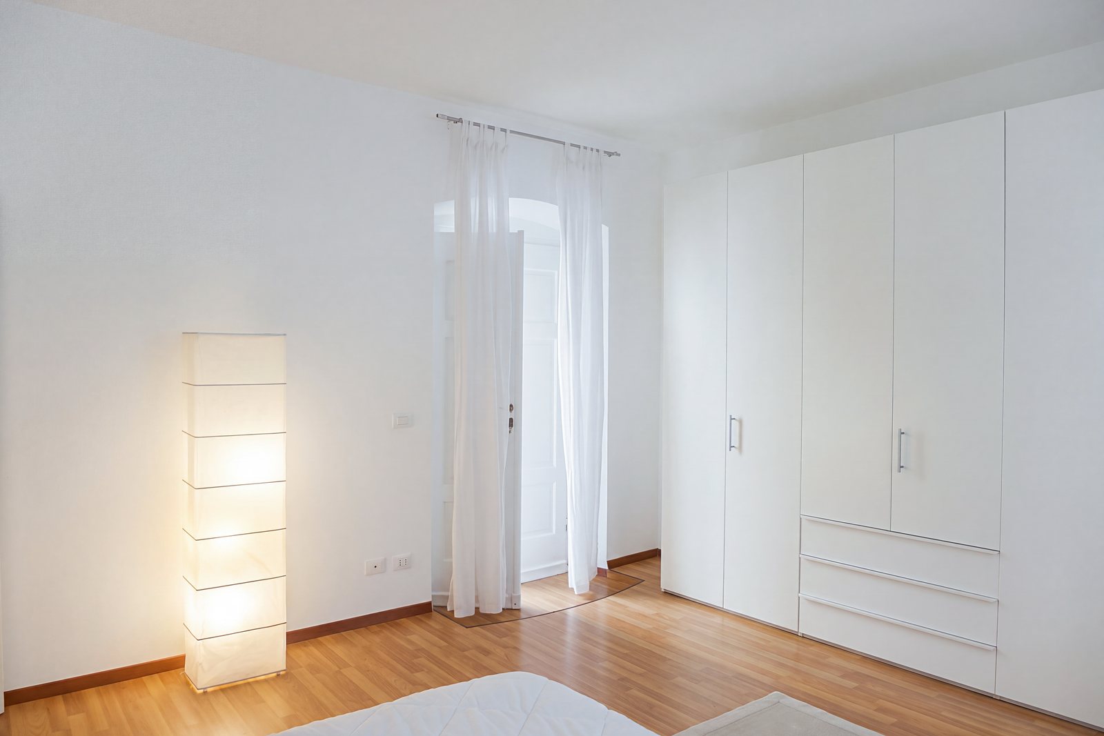 Schlafzimmer mit großem weißem Schrank und Fenstertür im Rundbogen, Viale della Terza Armata, Triest