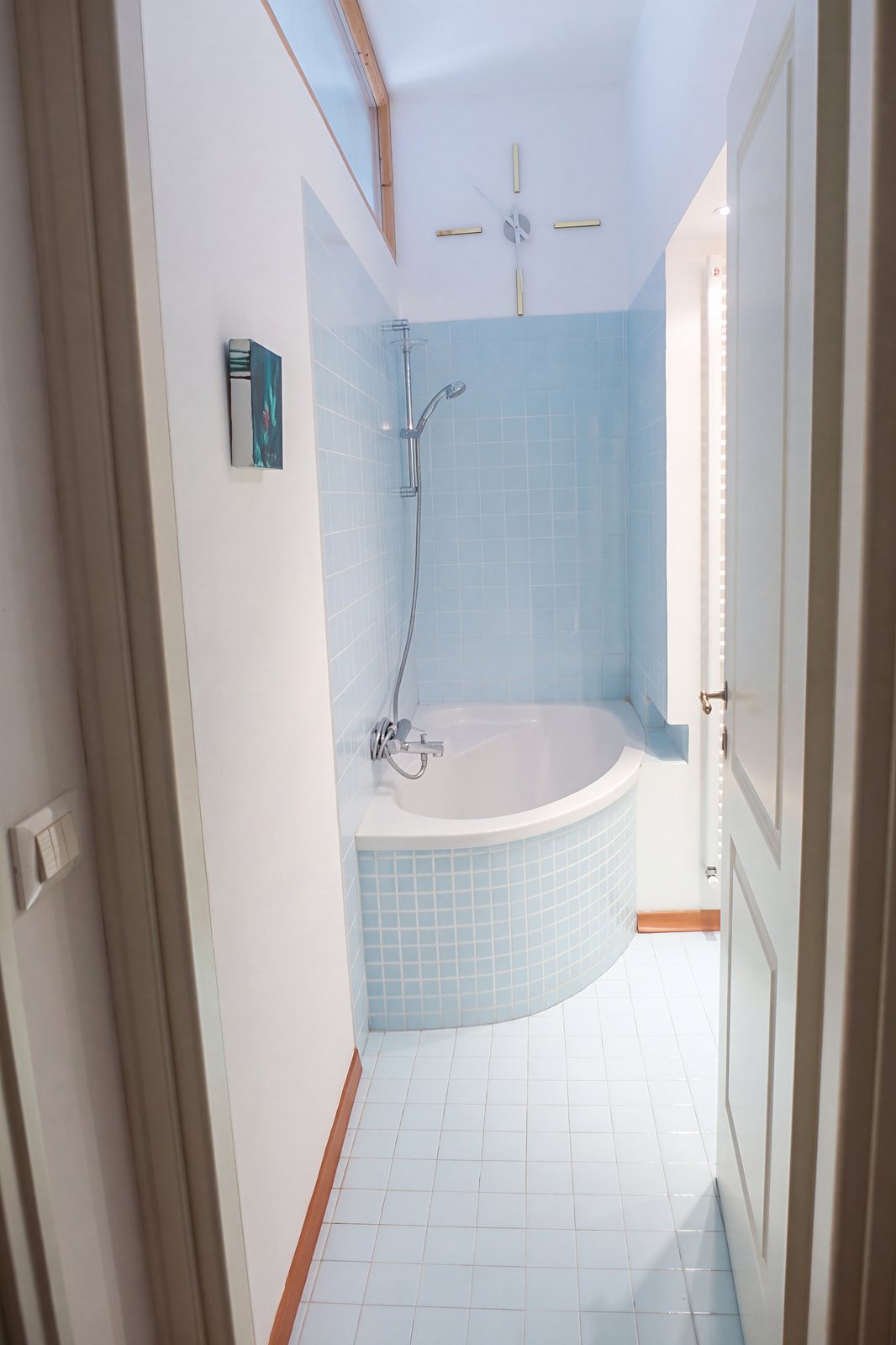 Bad mit Eckbadewanne in hellblauen Fliesen und Dusche, von der Tür aus, Viale della Terza Armata, Triest