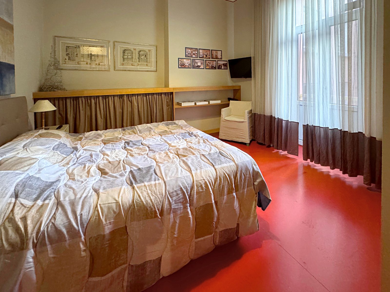 Double bedroom with red floor and long curtains at the French window, Via Santa Caterina, Trieste