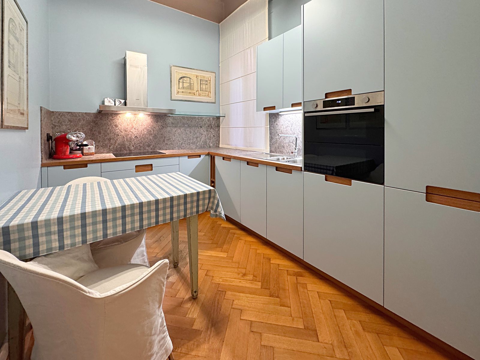 Pale blue kitchen with built-in oven, corner worktop and table, Via Santa Caterina, Trieste