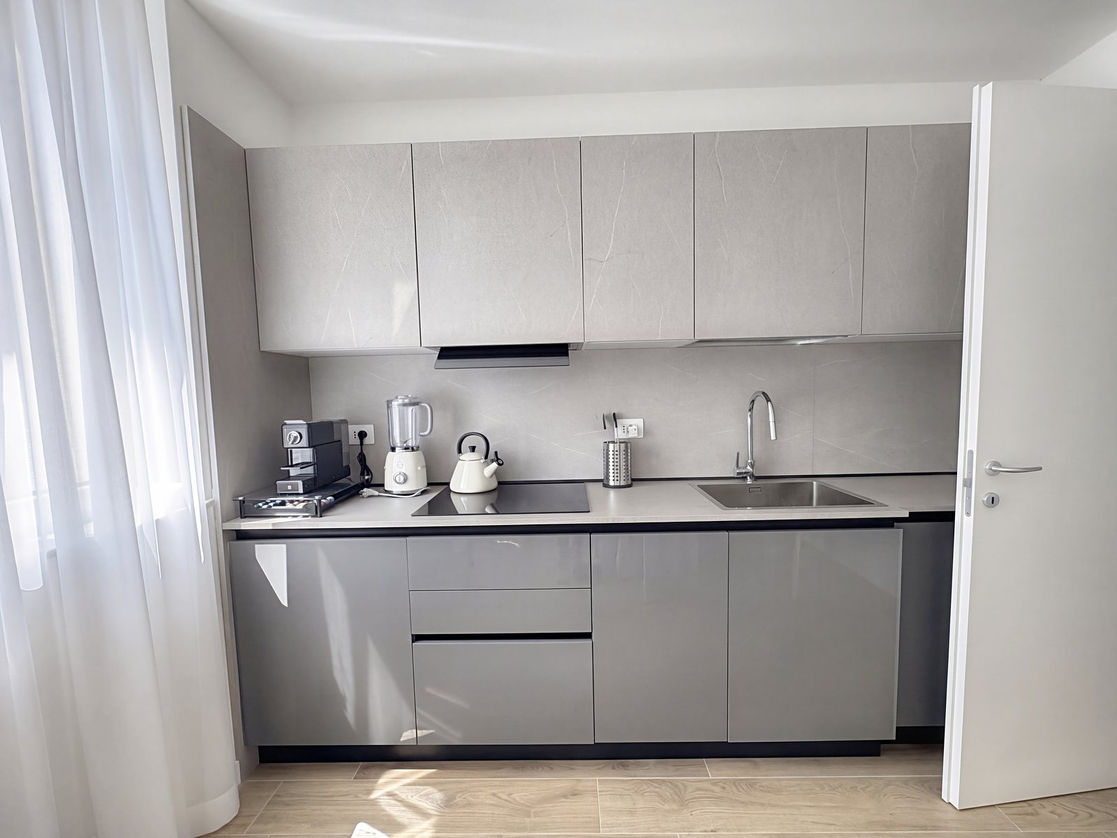 Kitchen with stone-effect wall cabinets, glossy grey base units, sink and hob, Salita di Gretta, Trieste