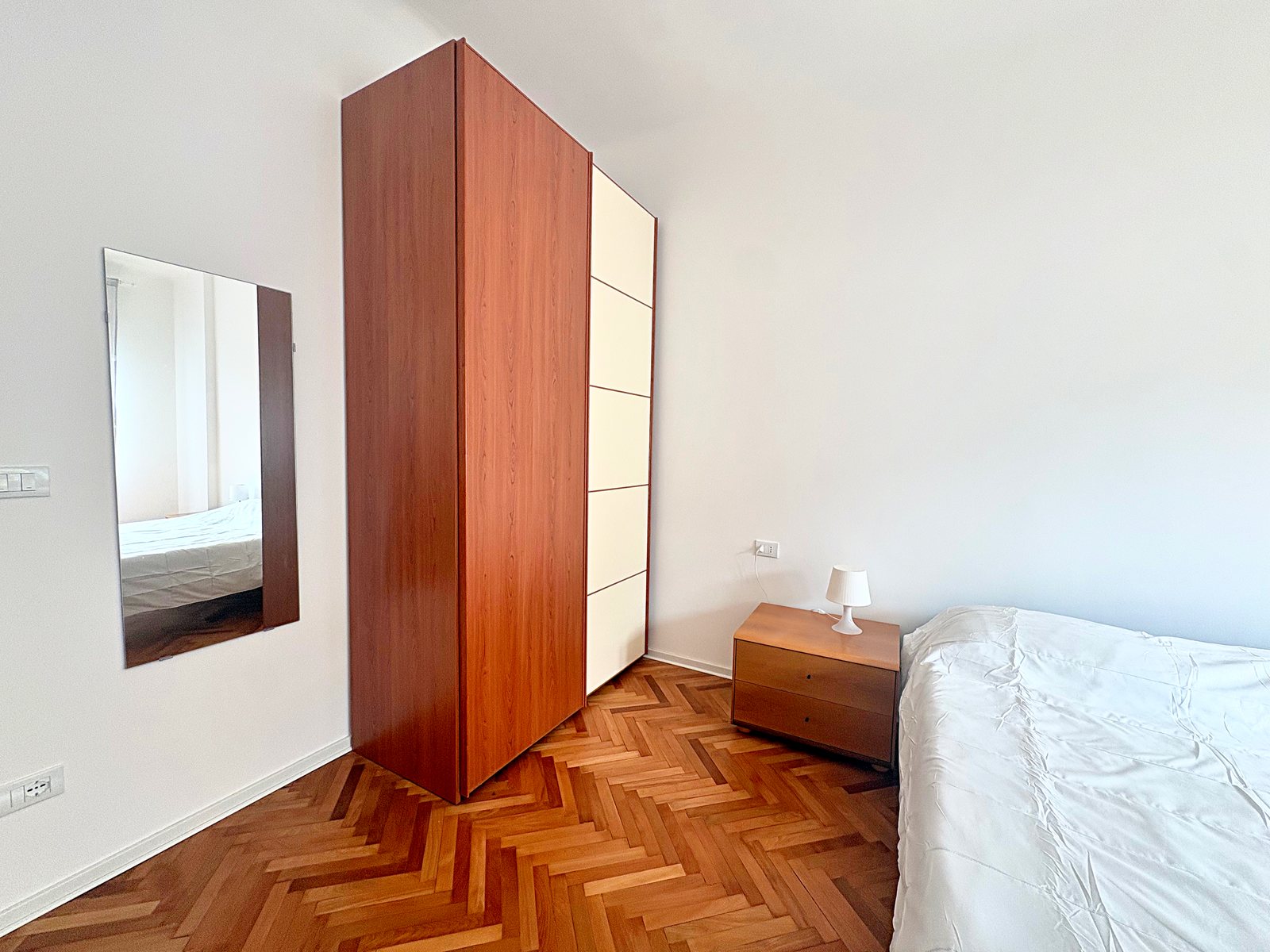 Camera matrimoniale: armadio in ciliegio e crema, specchio a parete e parquet a spina di pesce, Trieste