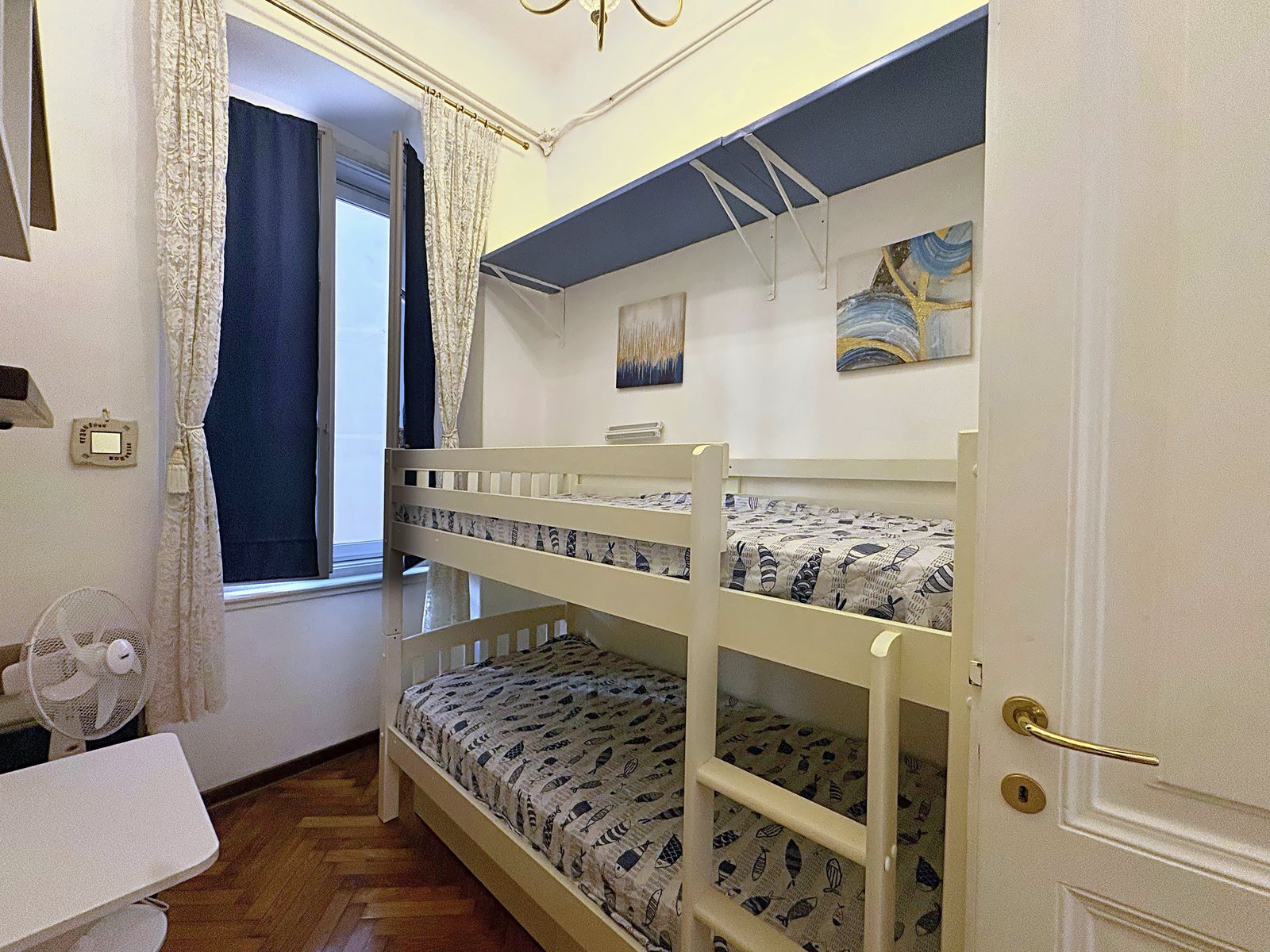 Cameretta con letto a castello, tende blu e due quadri astratti, via San Giorgio, Trieste