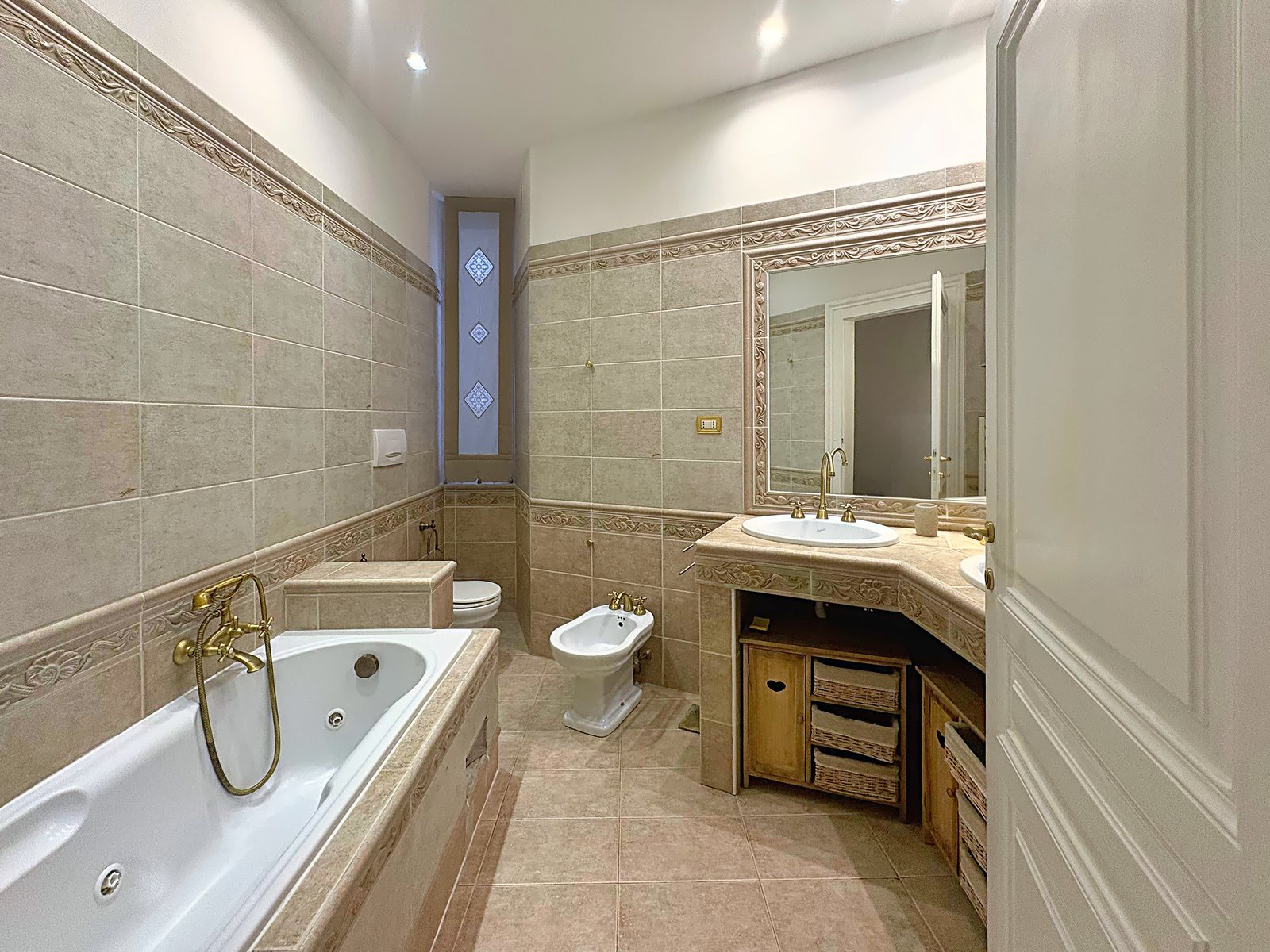 Bagno con vasca idromassaggio, bidet, wc e mobile lavabo piastrellato, via San Giorgio, Trieste