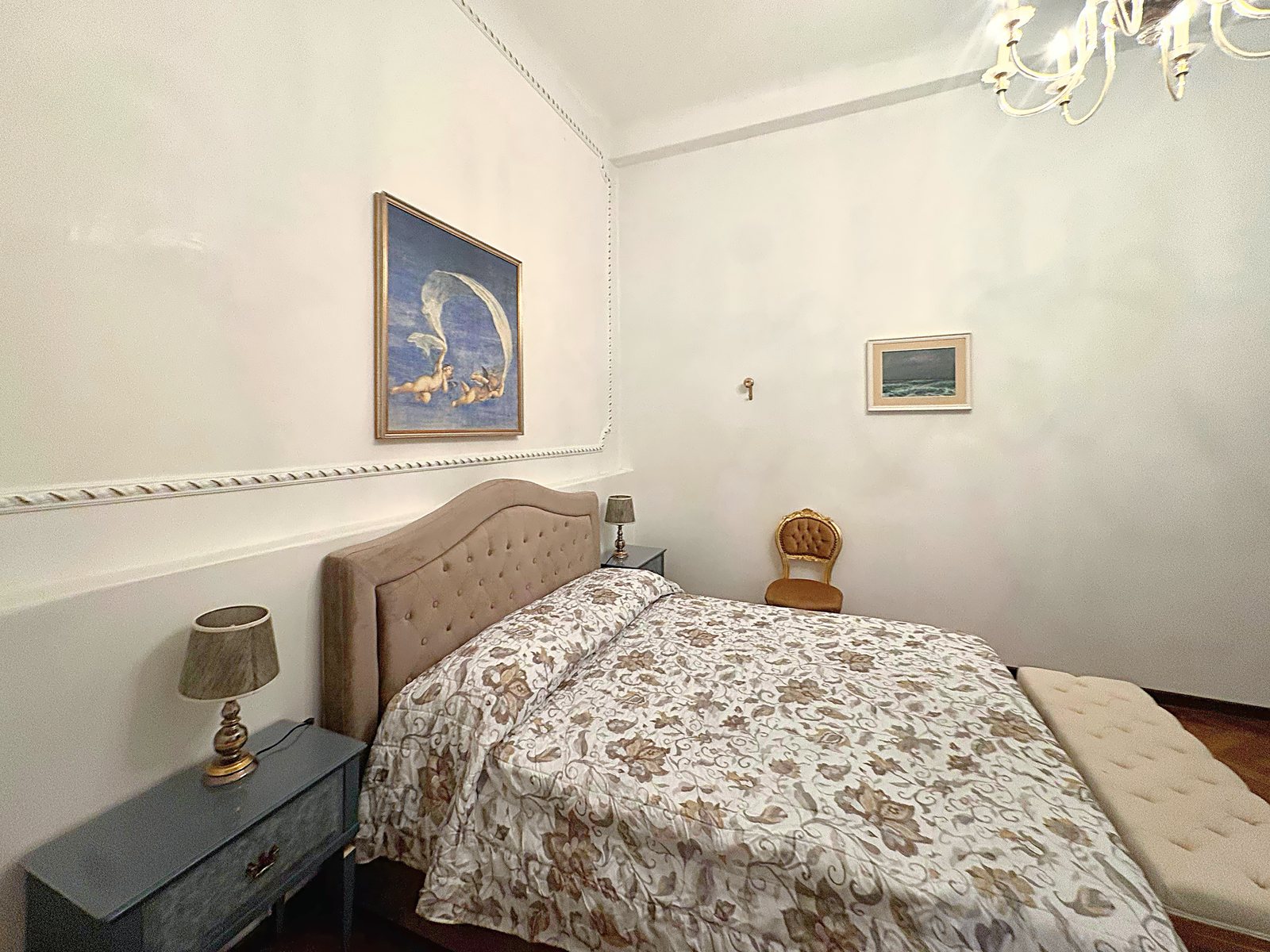 Camera matrimoniale con testiera imbottita, comodini azzurri e quadro con putti, via San Giorgio, Trieste