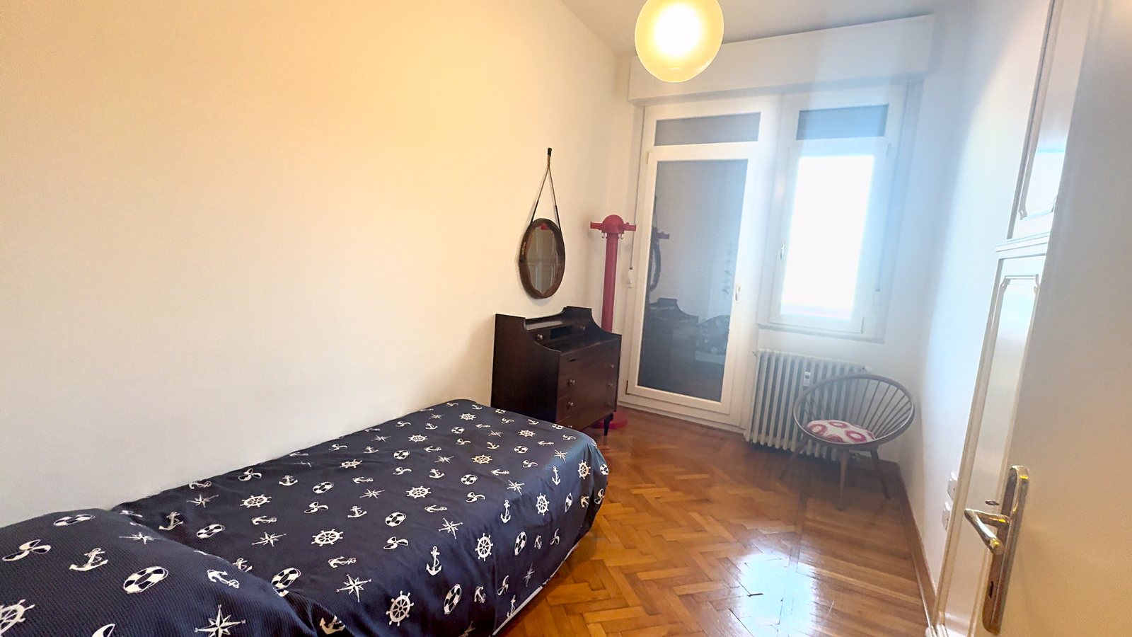 Enoposteljna soba s pregrinjalom z mornarskimi motivi, okroglim ogledalom in balkonskimi vrati, Via Belpoggio, Trst