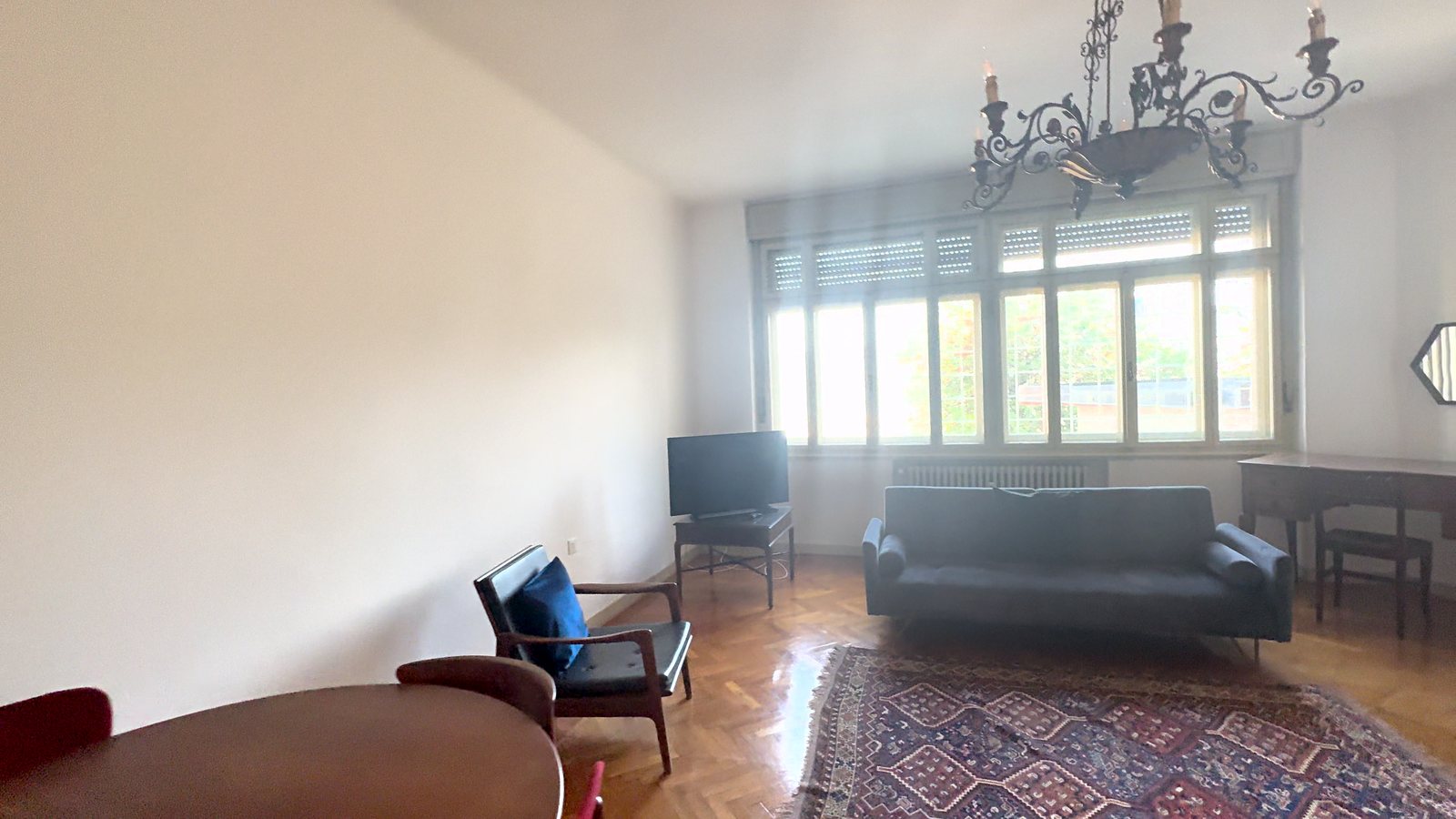 Dnevna soba z velikim svetlim erkerjem, kovanim lestencem in pisalno mizo, Via Belpoggio, Trst