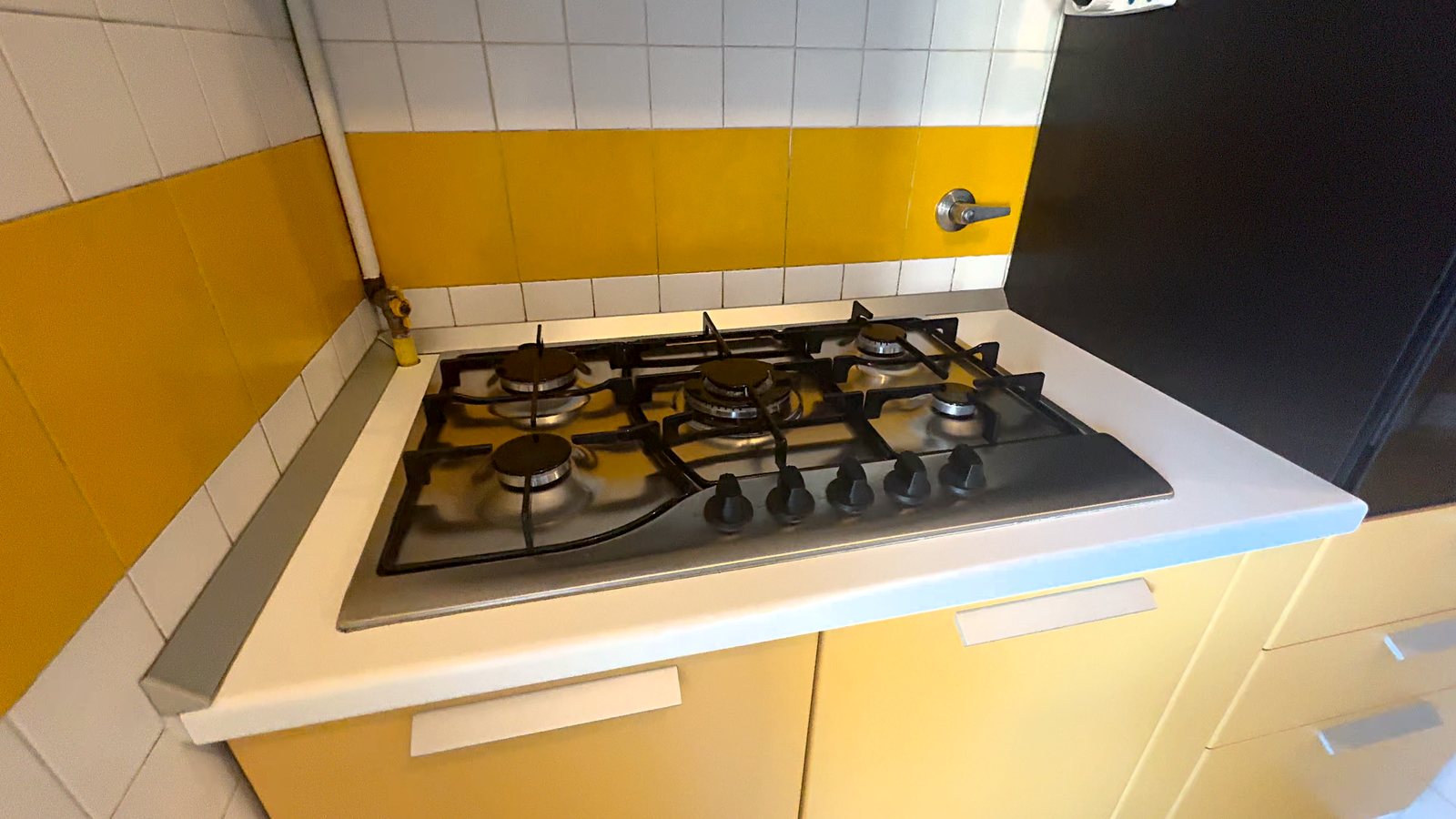 Čajna kuhinja s plinsko kuhalno ploščo s petimi gorilniki in rumenimi ploščicami, Via Belpoggio, Trst
