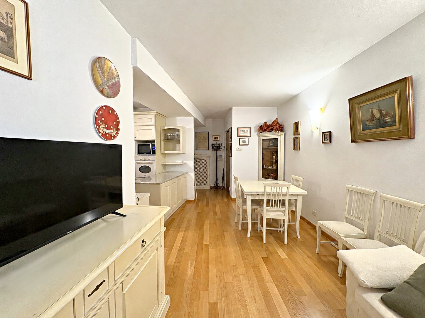 Living room with dining area, parquet floor and open kitchen at the back, Via del Trionfo, Trieste