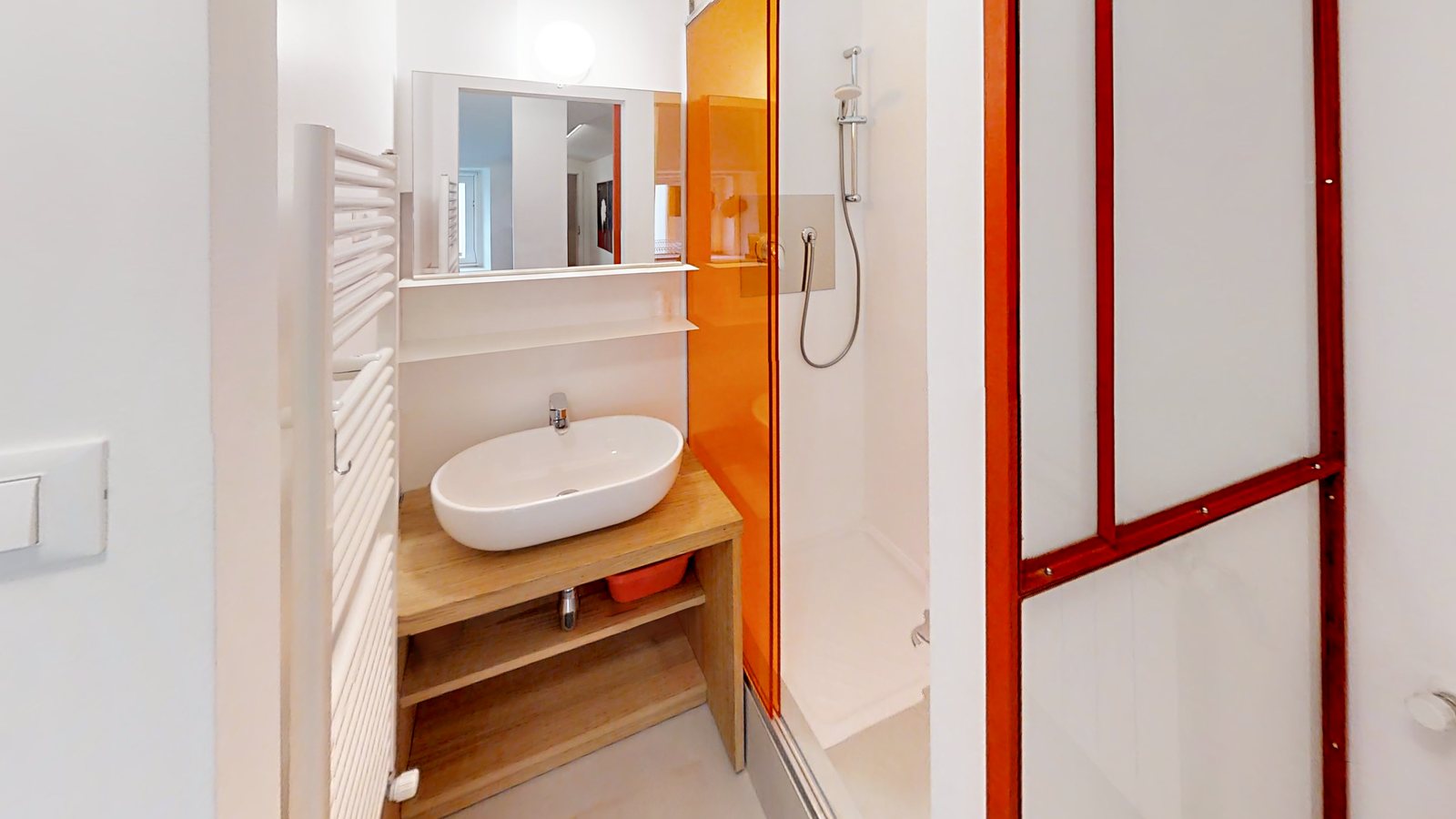 Duschbad mit Waschbecken auf Holzunterschrank und orangefarbener Duschwand, Via Corridoni, Triest