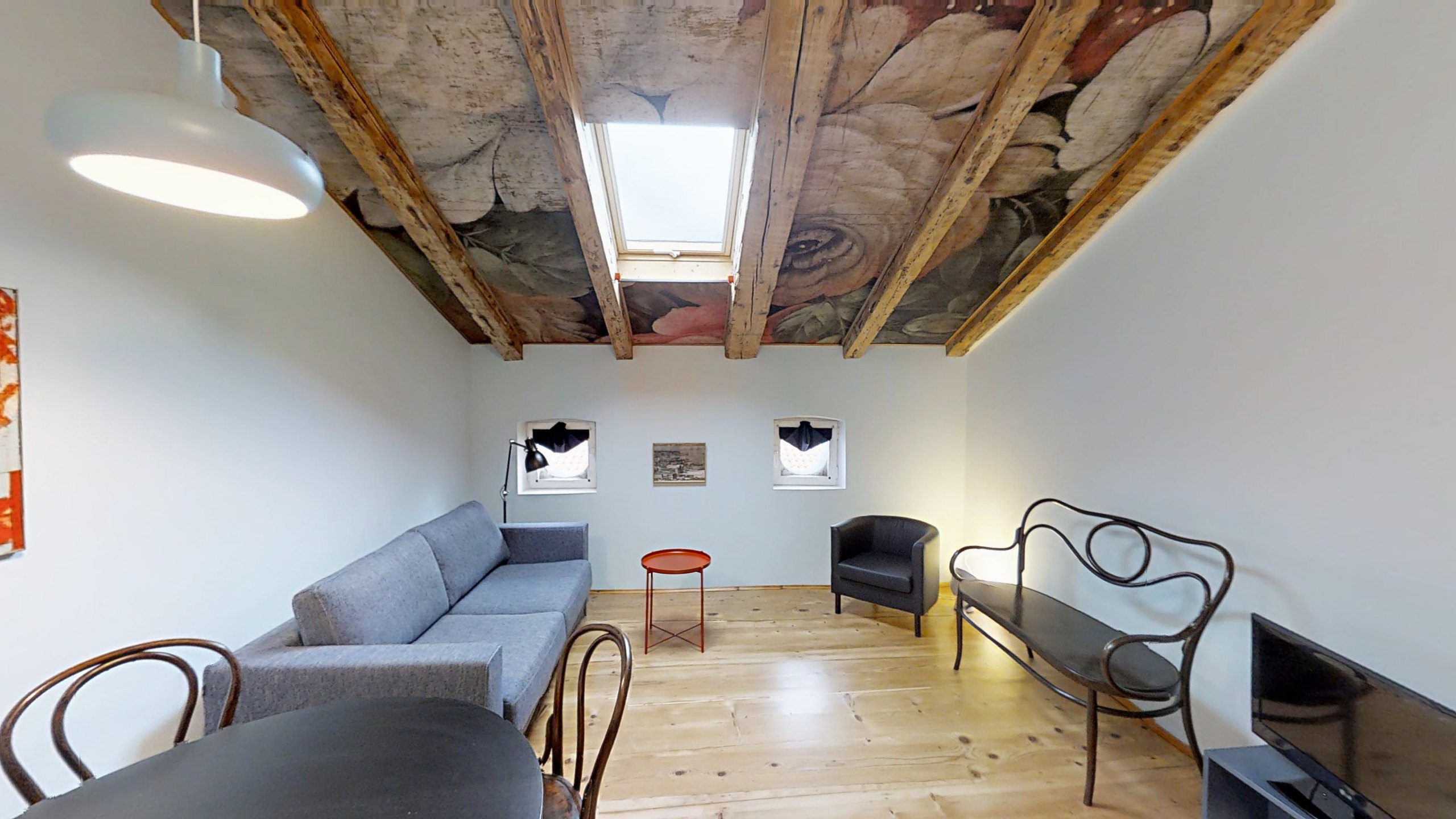 Wohnzimmer im Dachgeschoss mit Holzbalken und Decke mit großen Blumenmotiven, Via Corridoni, Triest