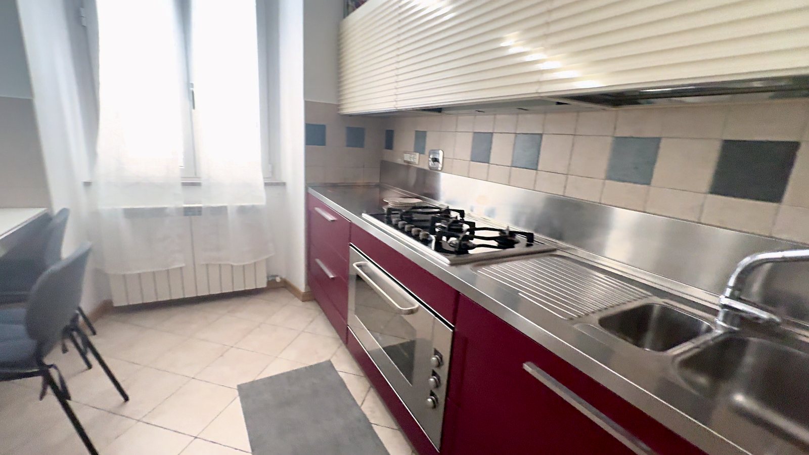 Cucina bordeaux con piano in acciaio, fornelli a gas e forno, Via XXX Ottobre, Trieste