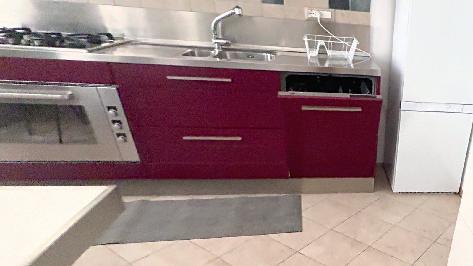 Cucina bordeaux con lavello doppio, lavastoviglie e frigorifero, Via XXX Ottobre, Trieste