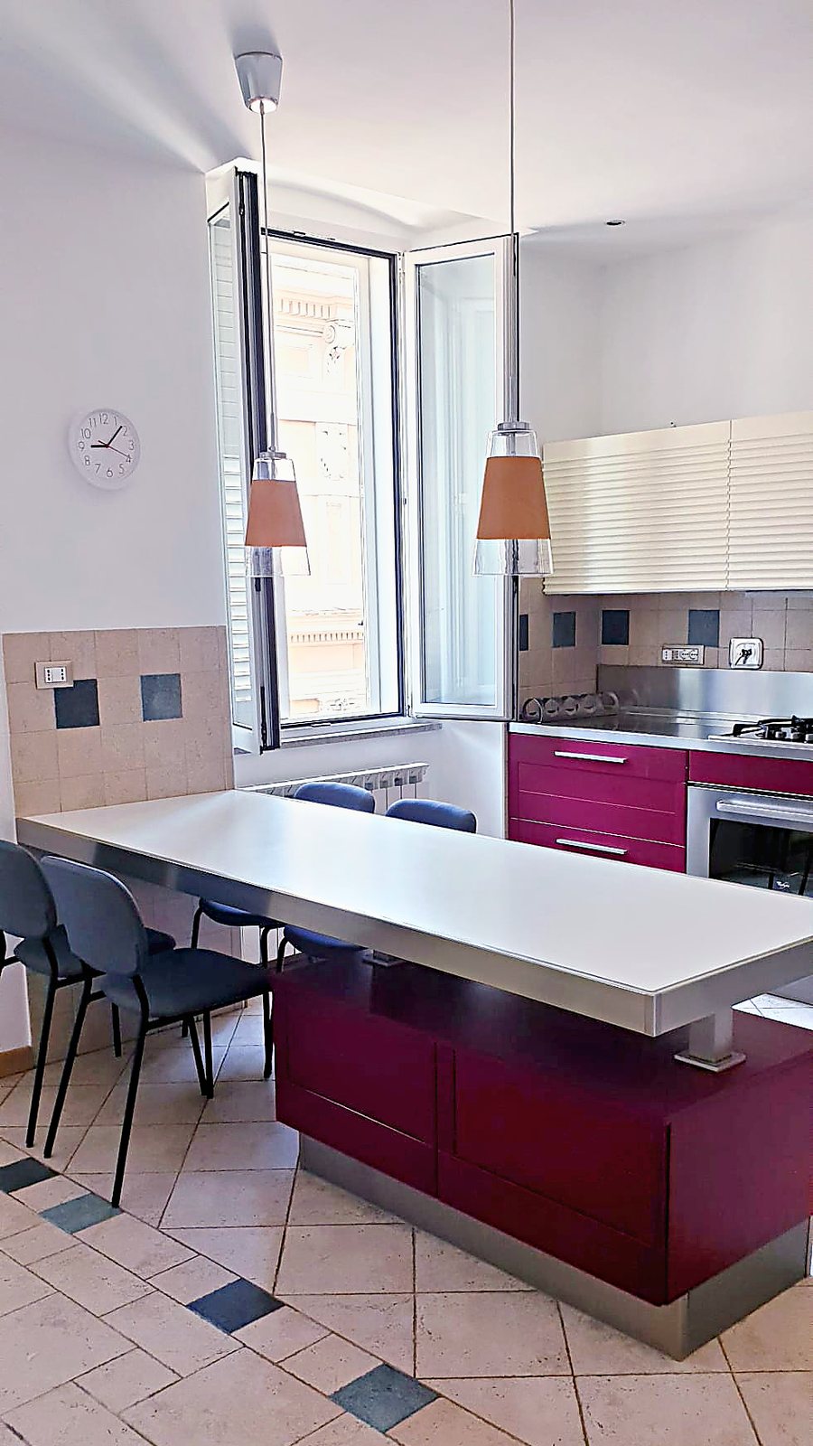 Cucina con penisola, lampade arancio e finestra sul palazzo di fronte, Via XXX Ottobre, Trieste