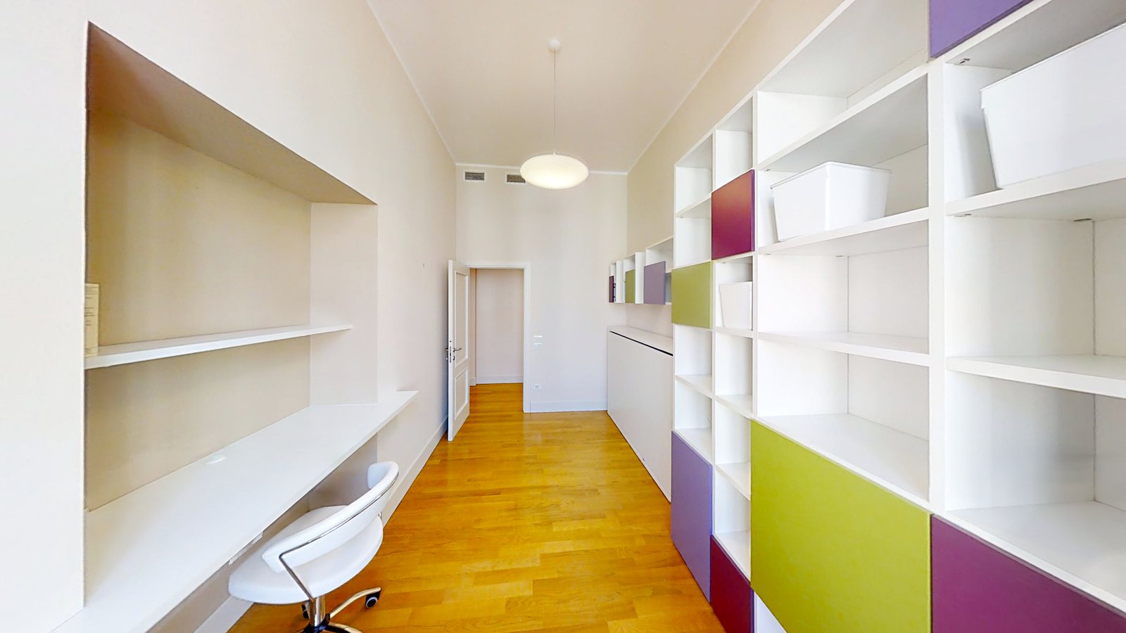 Arbeitszimmer mit Schreibtisch in Nische und weißem Regal mit lila und limettengrünen Paneelen, Palazzo Tergesteo, Triest
