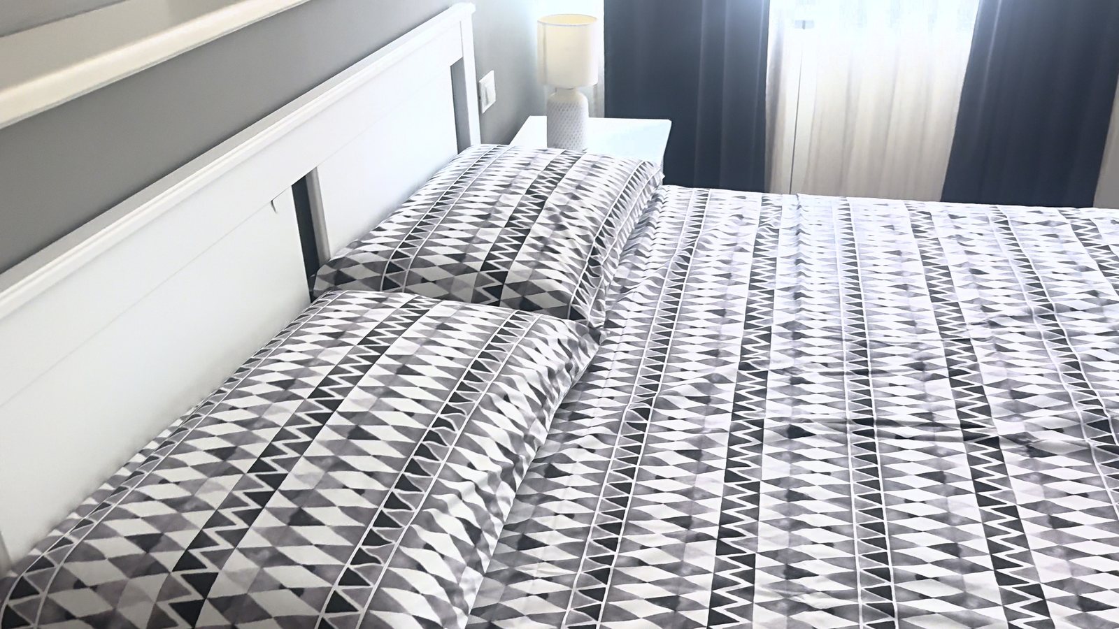 Letto matrimoniale con testiera bianca e copripiumino a triangoli bianchi e neri, Via del Lazzaretto Vecchio, Trieste