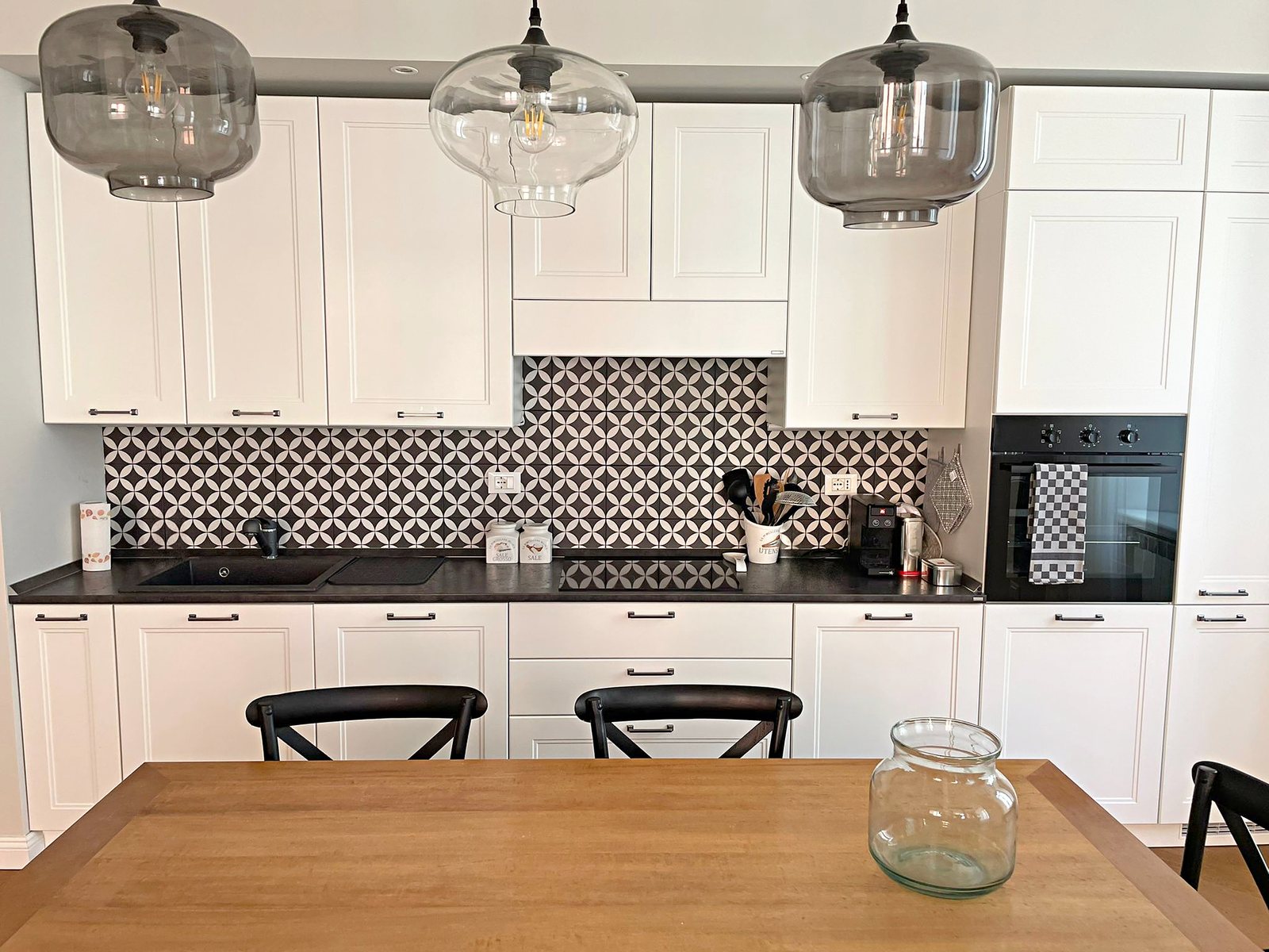 Cucina bianca con piastrelle geometriche bianche e nere, piano nero e forno, Via del Lazzaretto Vecchio, Trieste