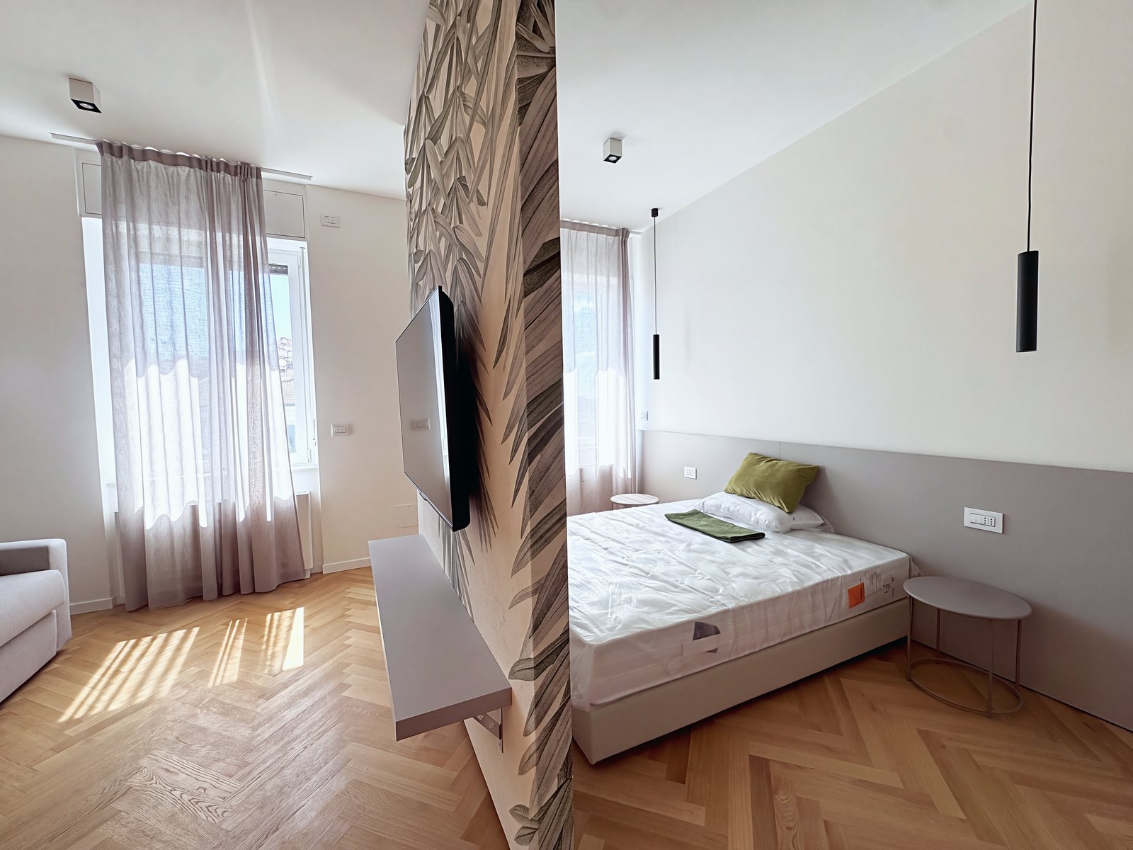 Zona notte con letto matrimoniale accanto alle due finestre su piazza Goldoni, via Carducci, Trieste