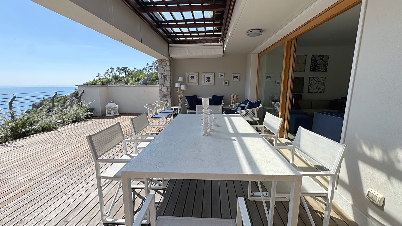 Covered terrace with dining table and view over the gulf, flat at Portopiccolo, Duino Aurisina