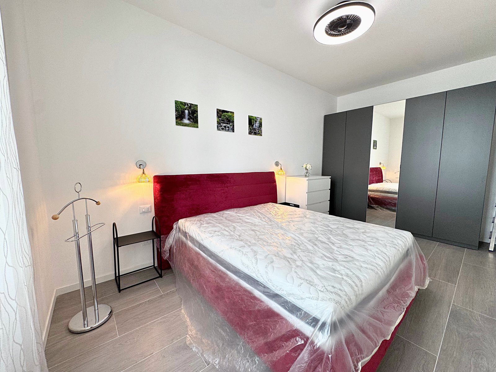 Camera matrimoniale con armadio antracite ad anta a specchio, comodini neri e servomuto, via del Lavatoio, Trieste