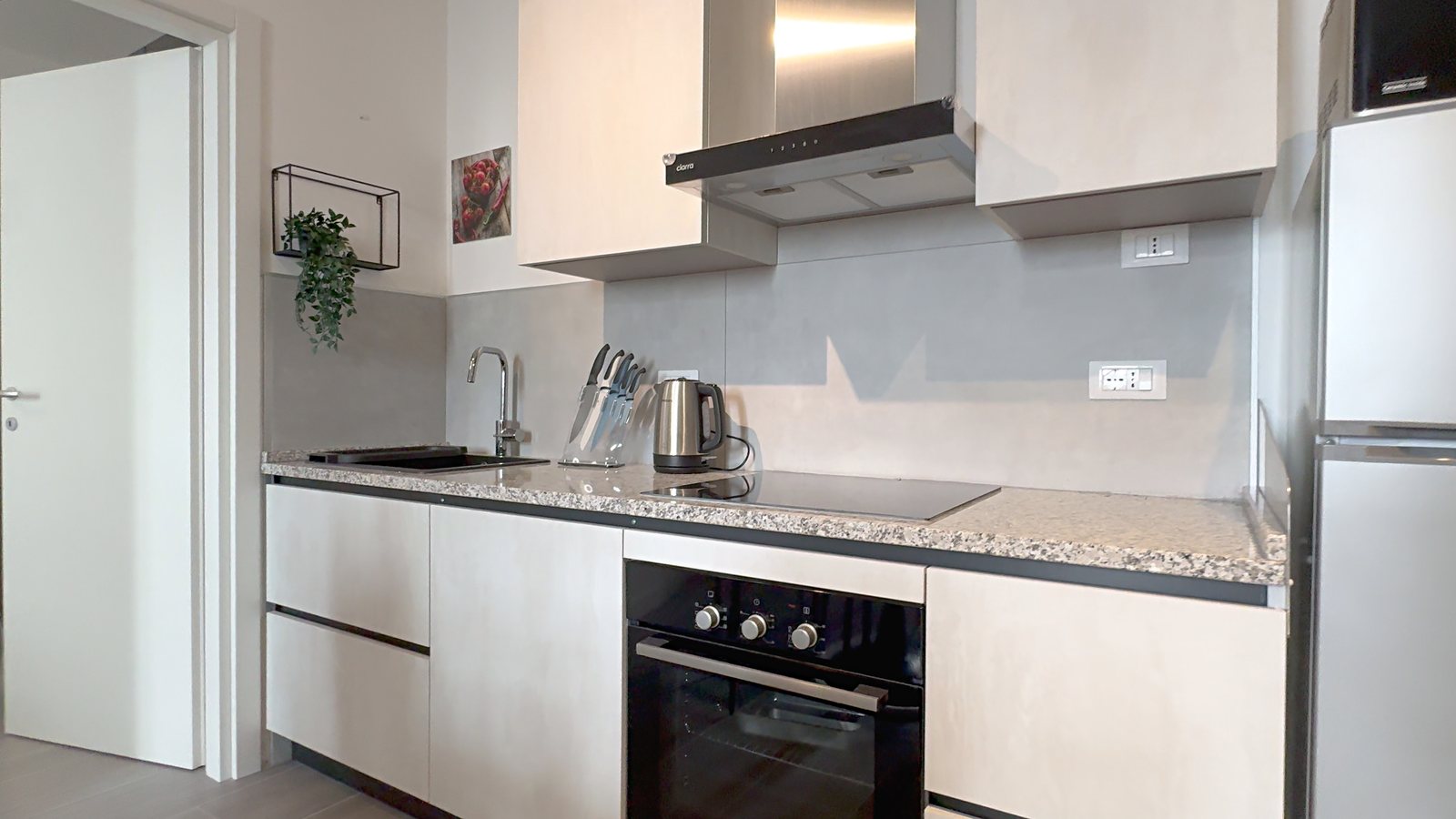 Cucina in linea con piano effetto granito, piano cottura, forno e cappa in acciaio, via del Lavatoio, Trieste