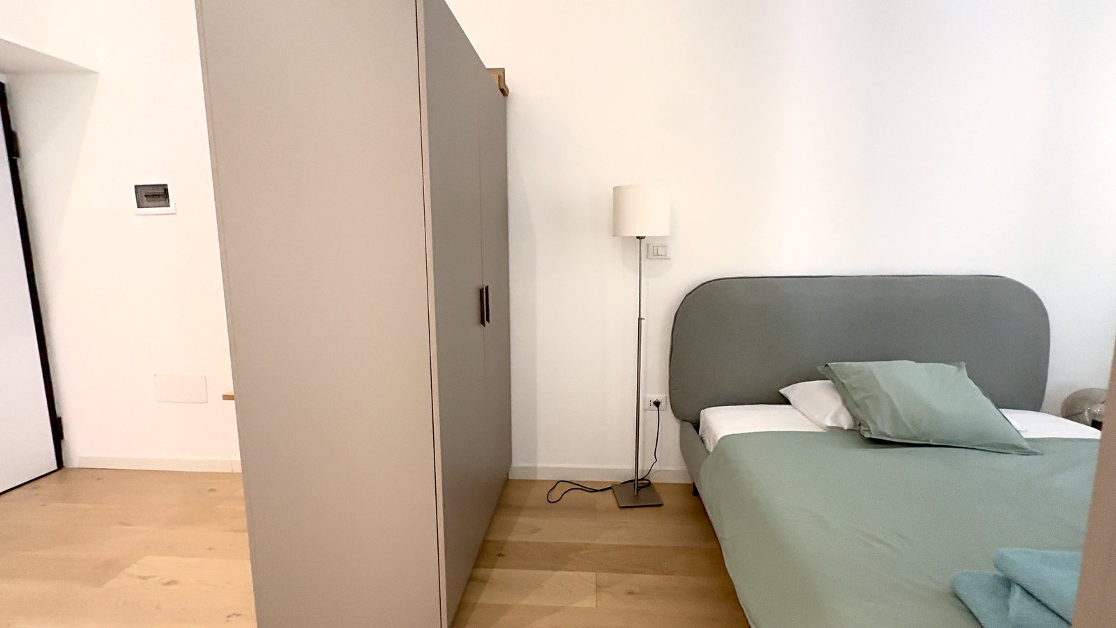 Schlafbereich mit zweitürigem Kleiderschrank, Stehlampe und Doppelbett, Via della Madonnina, Triest