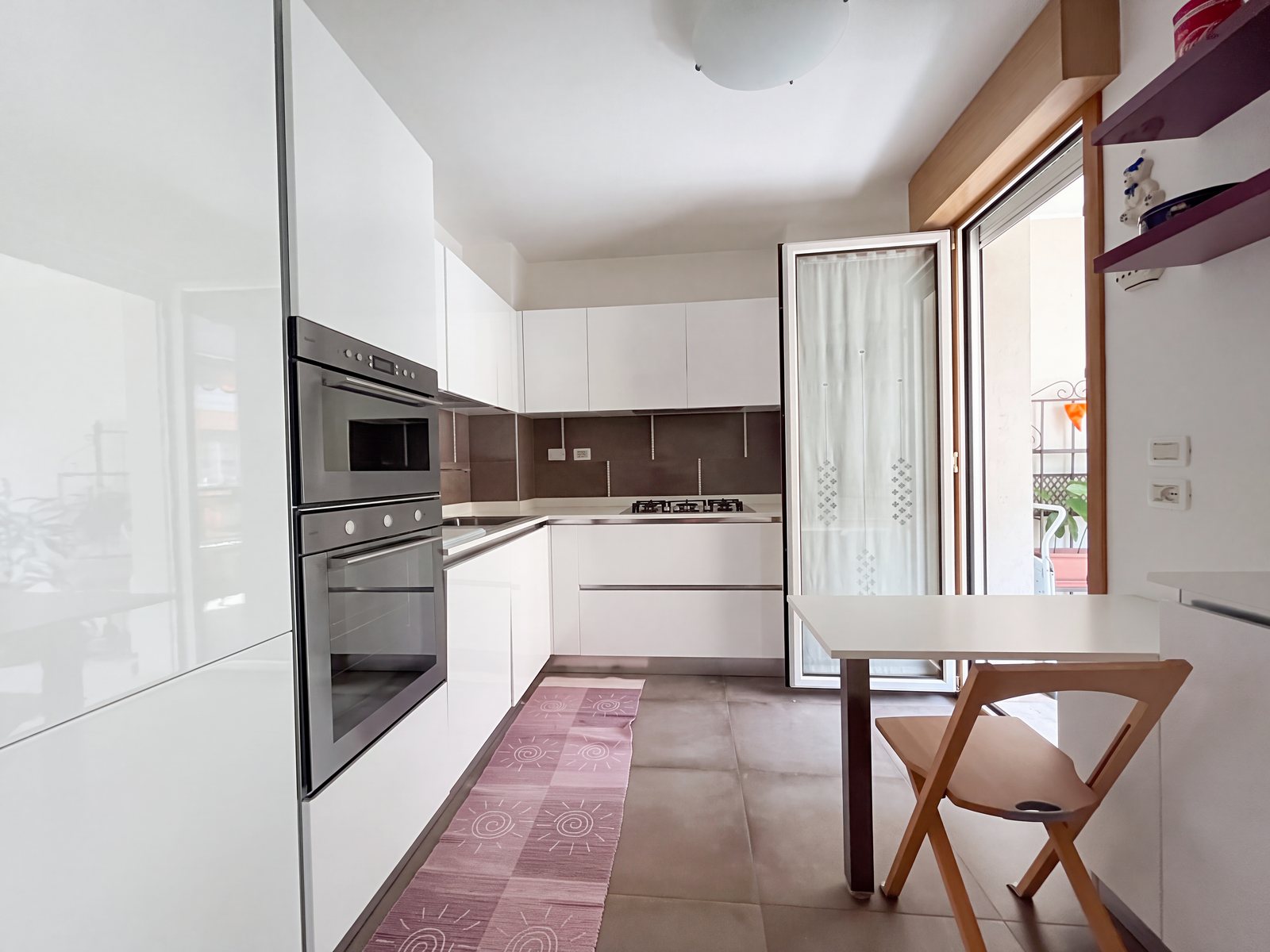 Bela visoko sijajna kuhinja z vgrajeno pečico in vrati na balkon, Via Tor San Piero, Trst