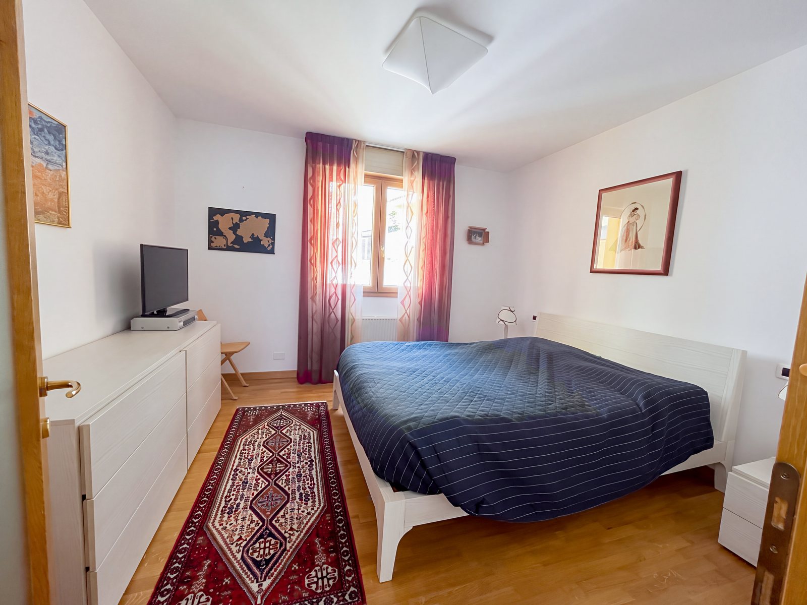 Spalnica z zakonsko posteljo, modrim pregrinjalom, rdečimi zavesami in orientalsko preprogo, Via Tor San Piero, Trst
