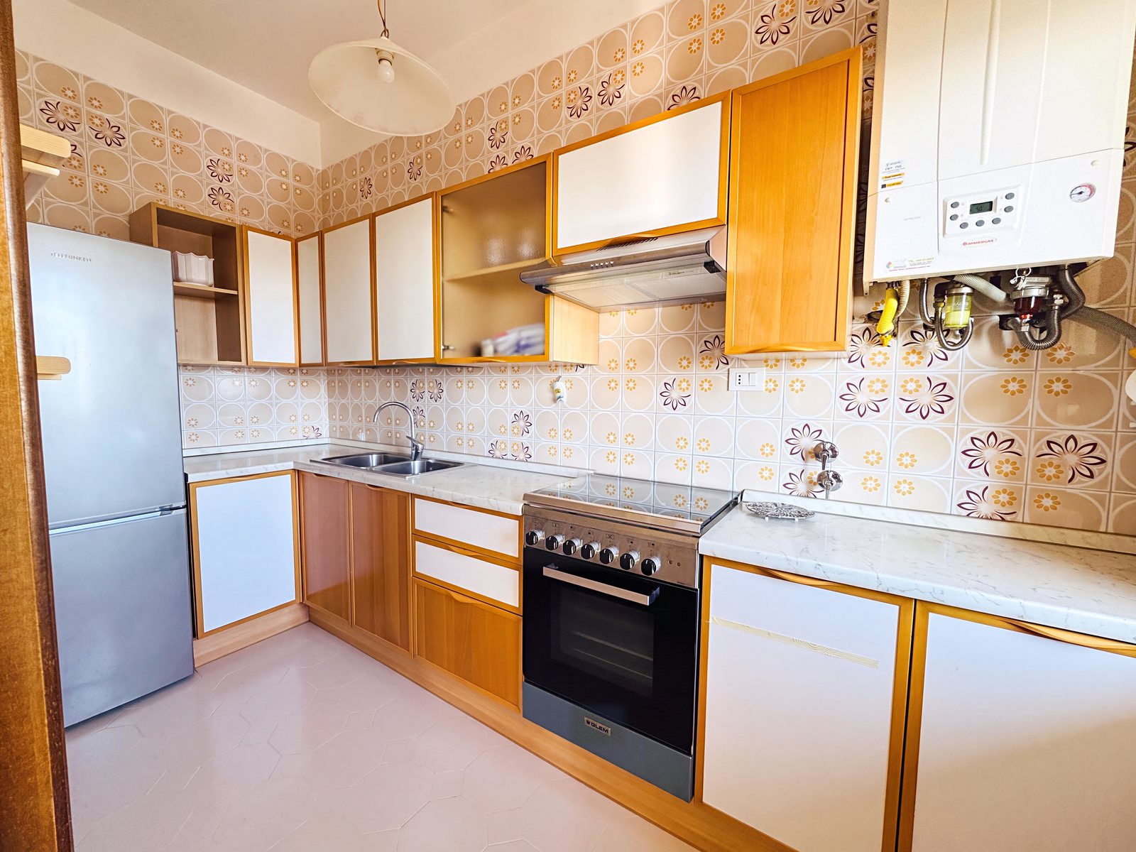 Kuhinja s cvetličnimi ploščicami iz 70. let, štedilnikom, hladilnikom in stenskim kotlom, Via Cividale, Trst