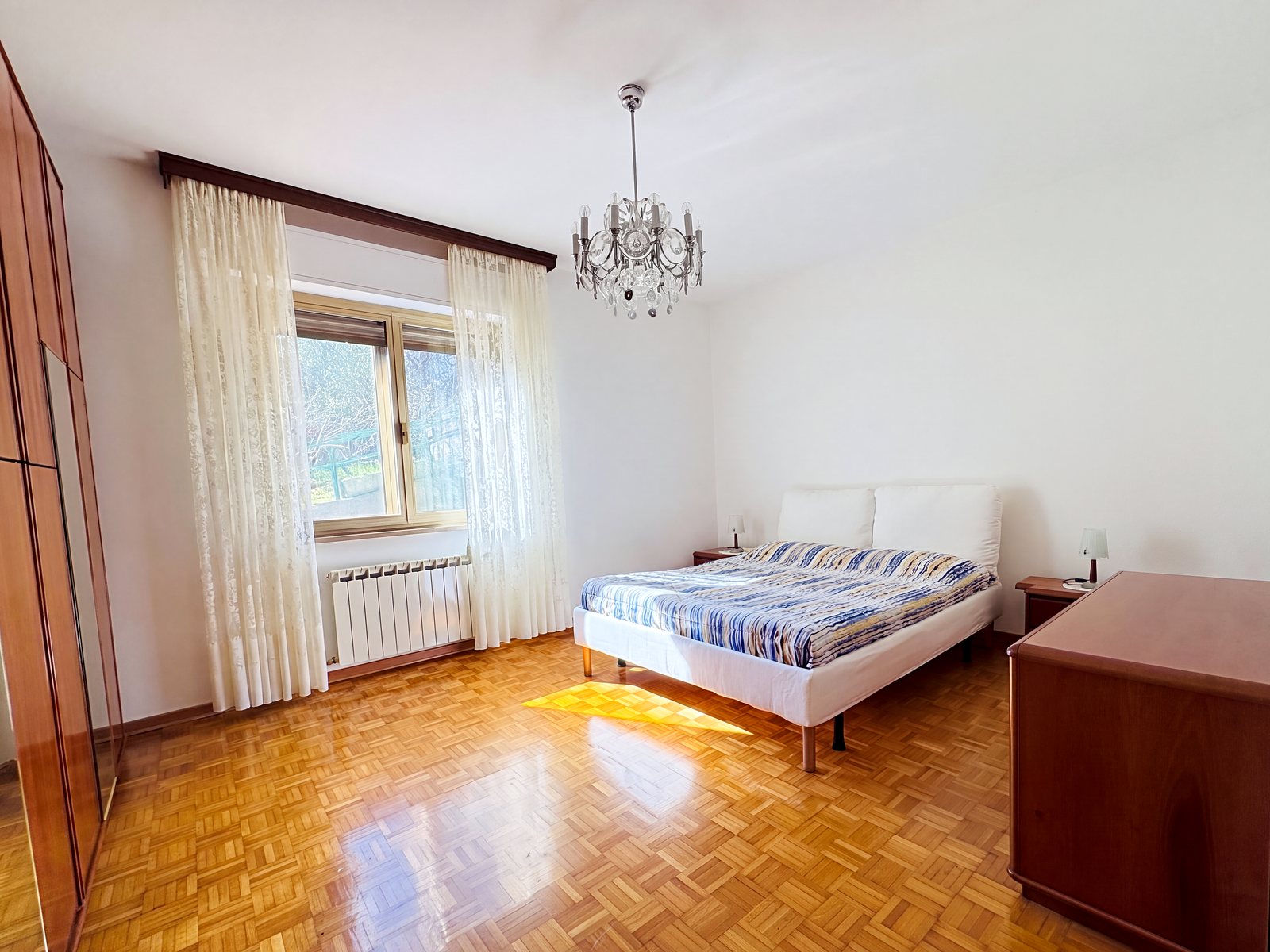 Zakonska spalnica s parketom, kristalnim lestencem in oknom na vrt, Via Cividale, Trst
